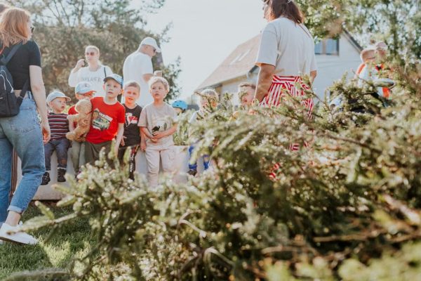 Children and adults participating in an outdoor educational activity surrounded by nature.